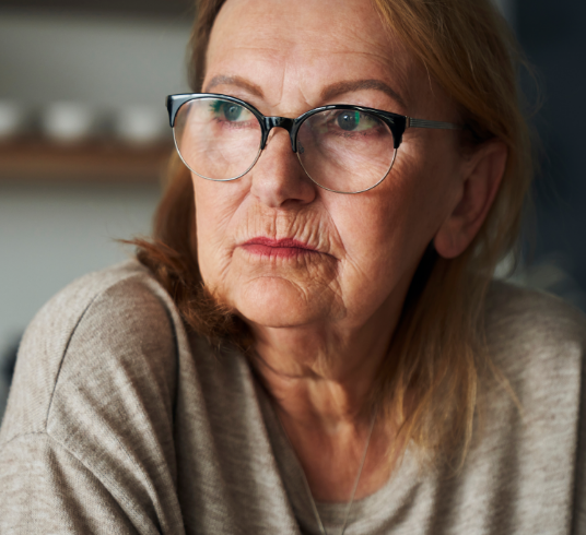 Image of female bladder cancer patient with a somber expression as if reflecting on health disparities